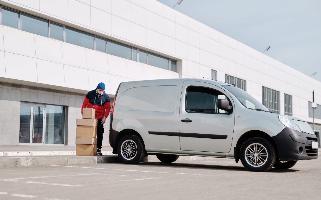 delivery man with boxes next to a white van
